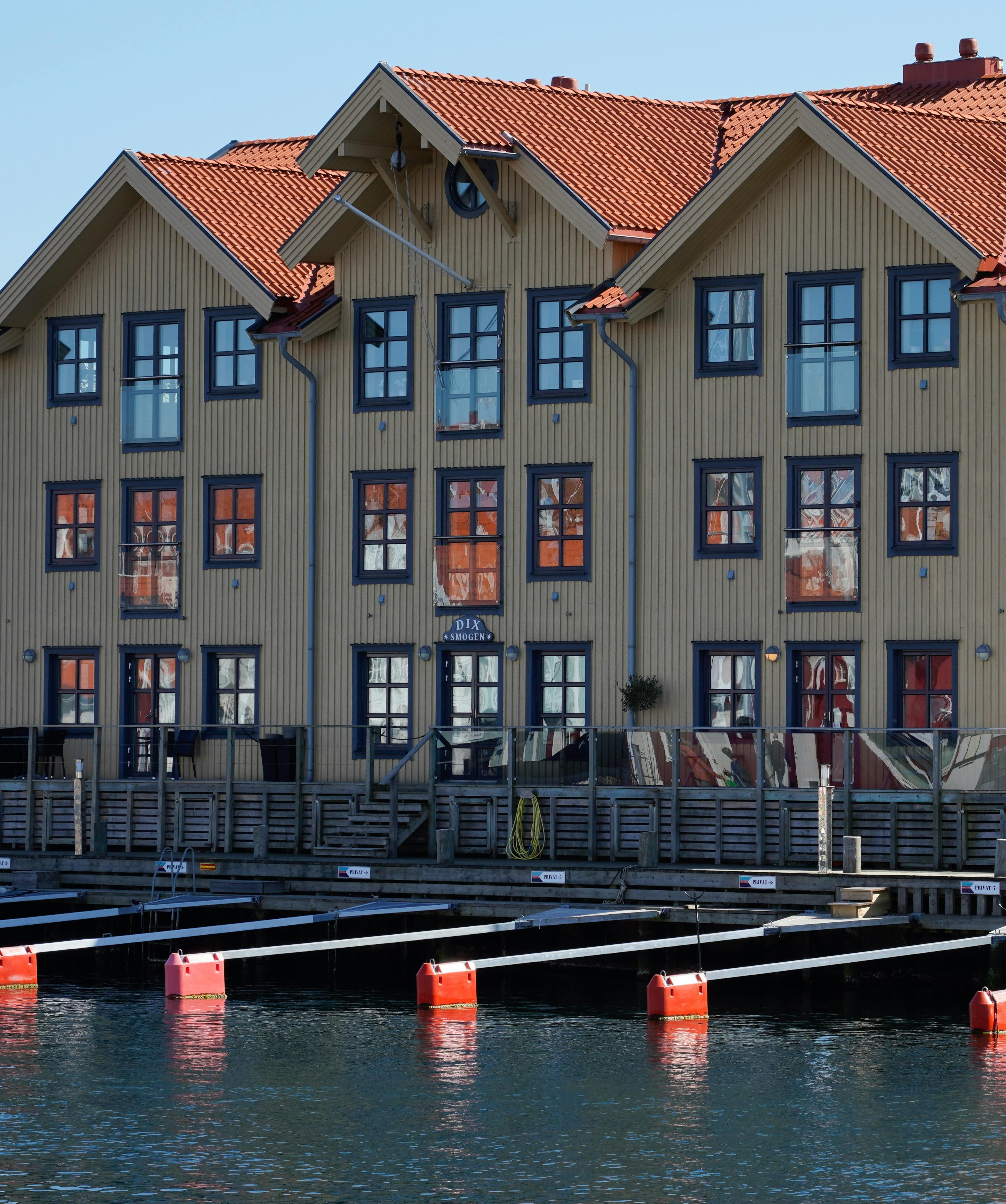 Multi-vånings träbyggnad vid hamn med strukturerade gavelfönster