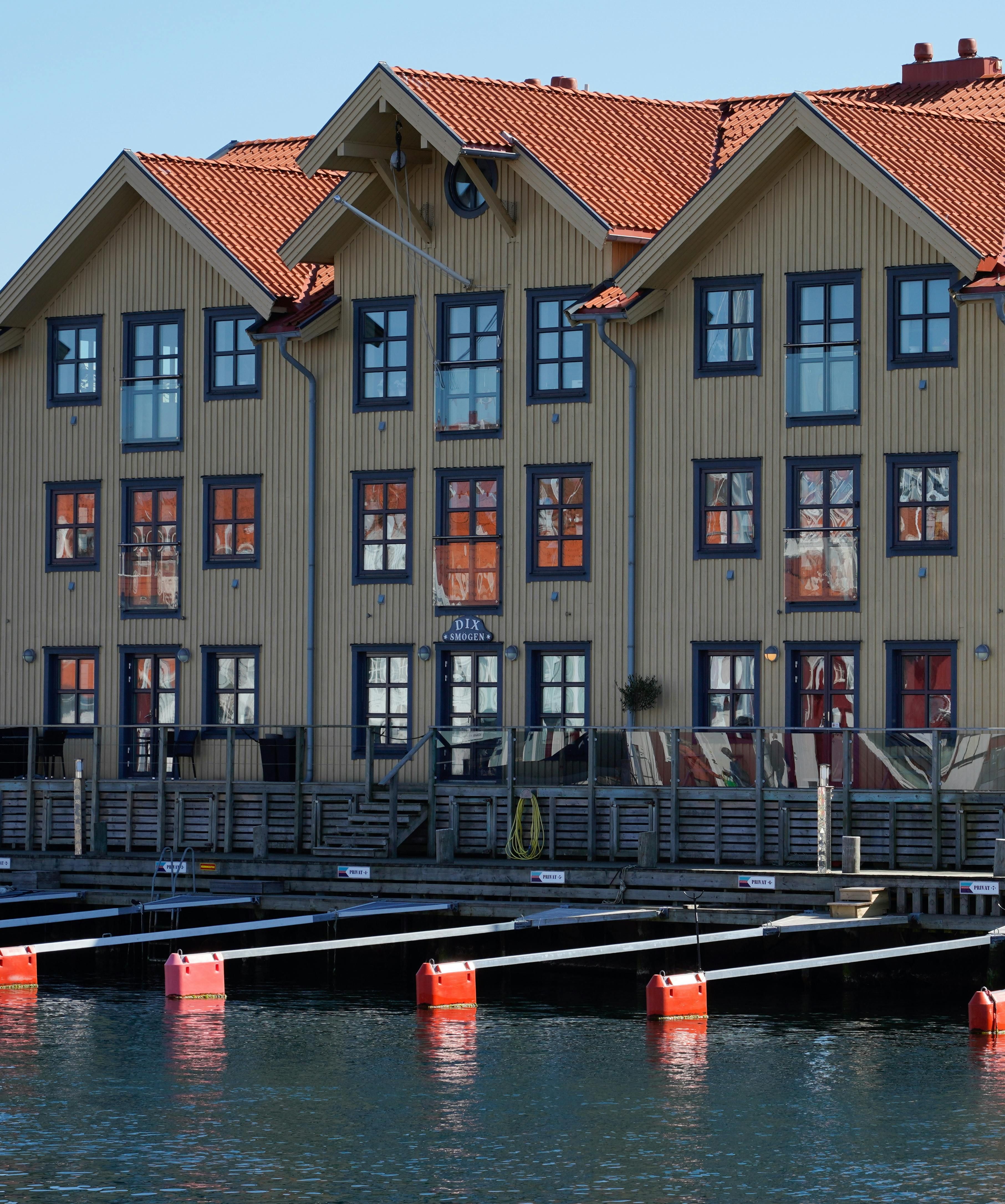 Multi-vånings träbyggnad vid hamn med strukturerade gavelfönster